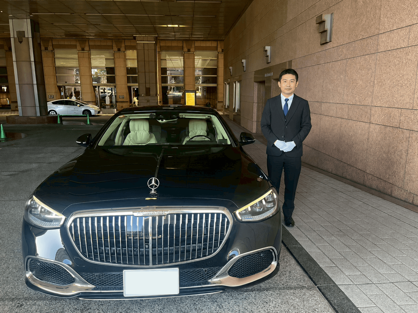 送迎車両のかたわらで待機する専属ドライバー